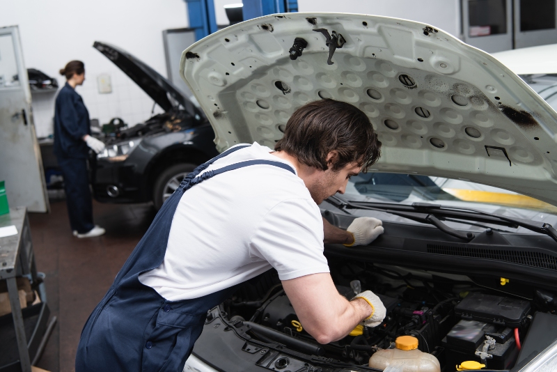 foreman-in-gloves-and-overalls-working-with-car-wi-2024-11-10-00-54-27-utc