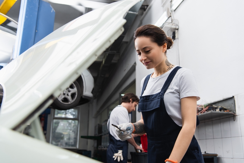 positive-mechanic-holding-wrench-near-car-with-blu-2024-11-10-16-09-11-utc